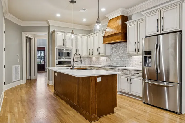 a kitchen with kitchen island granite countertop a sink appliances and cabinets