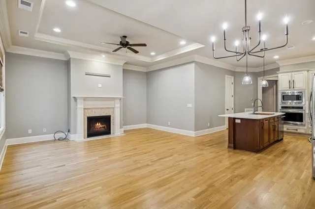 a view of a room with a fireplace and chandelier fan