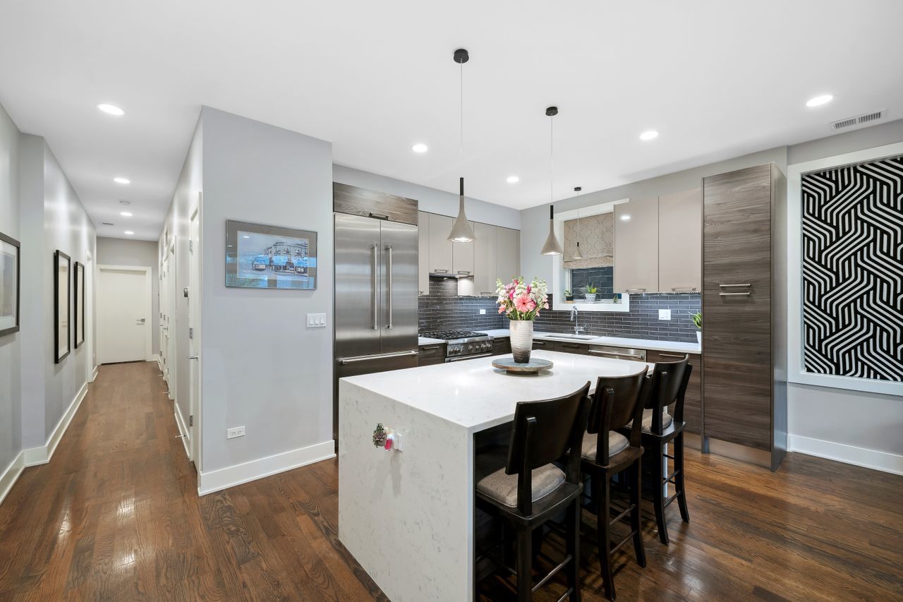 1224 West Ohio Street, Unit 2E Chicago, IL 60642 - Photo 6 of 17 a kitchen with stainless steel appliances kitchen island granite countertop a sink and cabinets