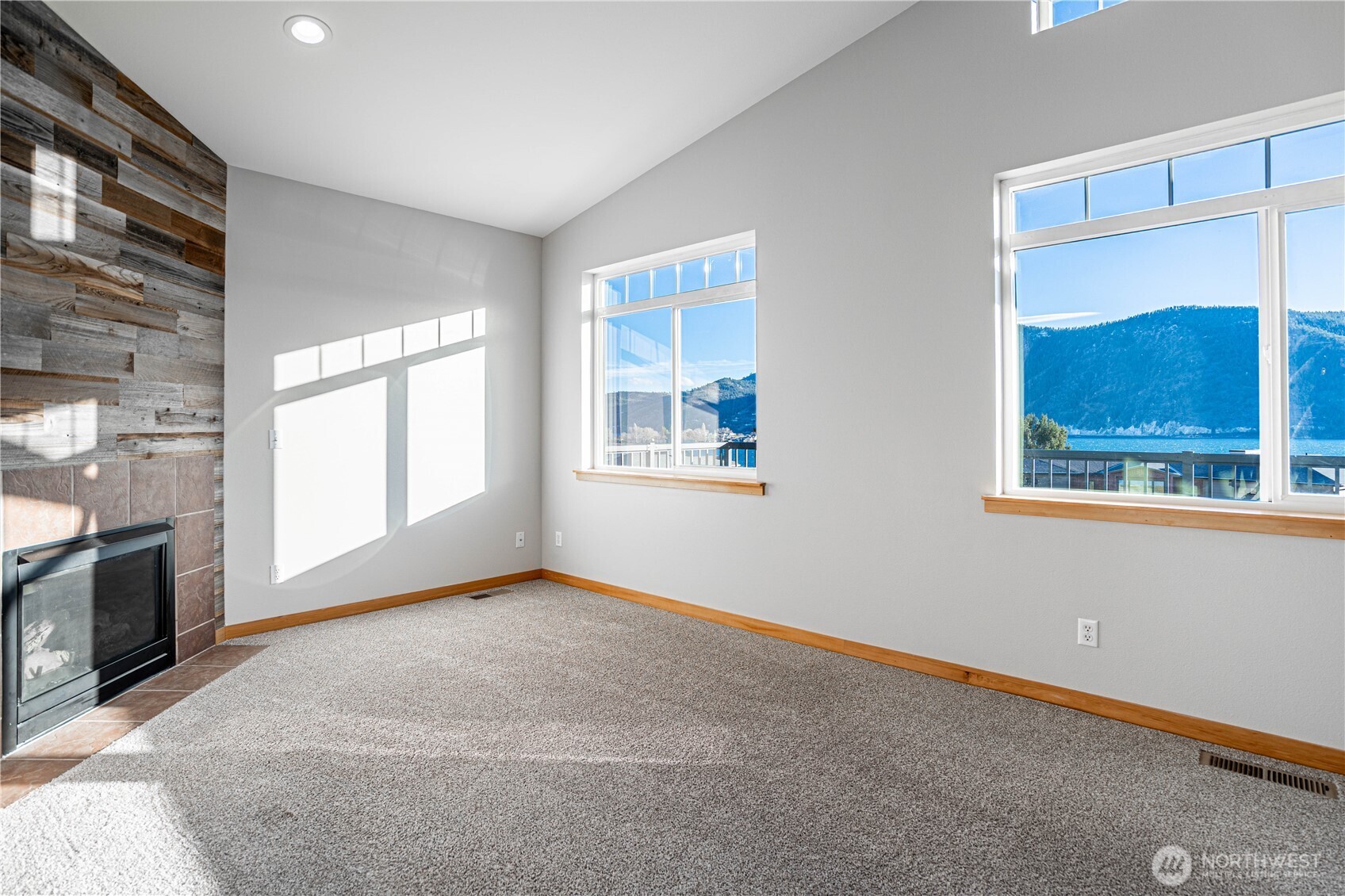 744 Wapato Way, Unit A Manson, WA 98831 - Photo 4 of 32 a view of an empty room with a window and a fireplace