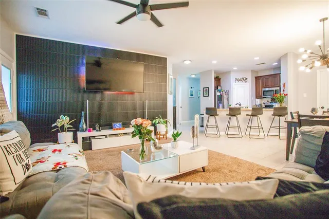 a living room with furniture and a view of kitchen