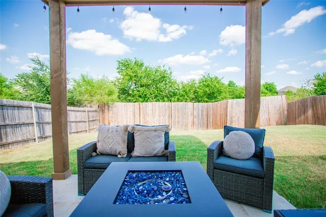a view of a yard in front of a house with a large tree