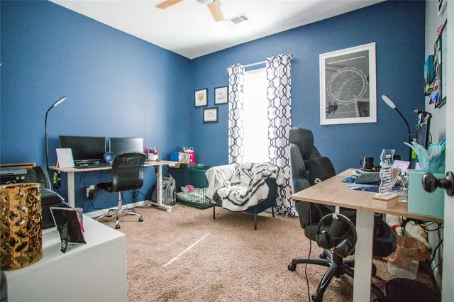 a view of a workspace with furniture and a window