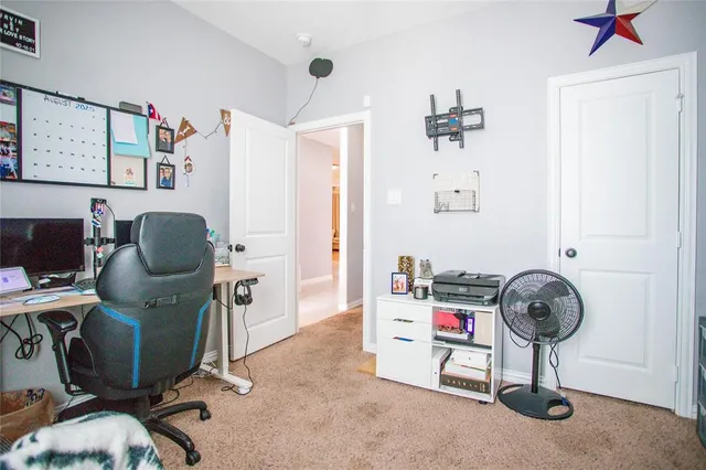 a bedroom with a bed a painting on the wall and a window
