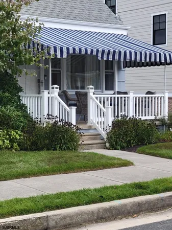 a view of a house with a yard and large tree