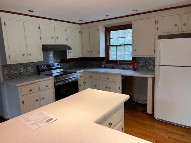a kitchen with a sink a stove and cabinets
