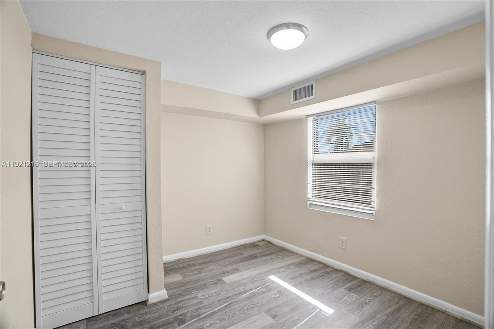 212 Southwest 11th Street Dania Beach, FL 33004 - Photo 12 of 39 a view of an empty room with wooden floor and a window