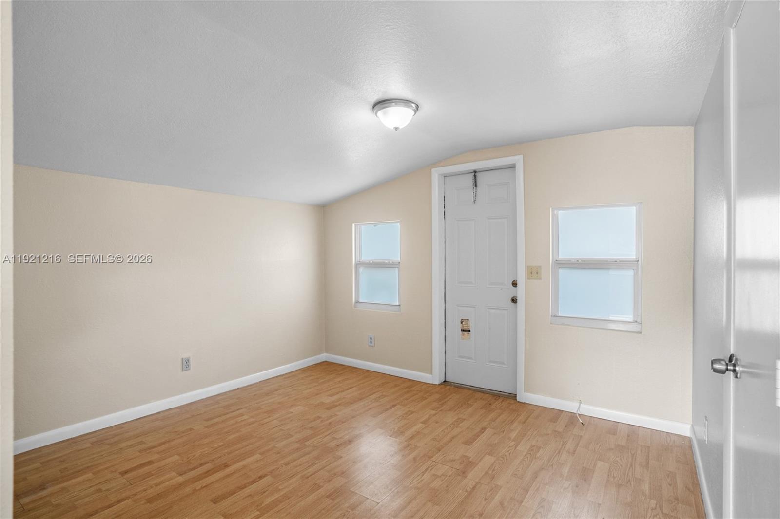 212 Southwest 11th Street Dania Beach, FL 33004 - Photo 21 of 39 an empty room with wooden floor and windows