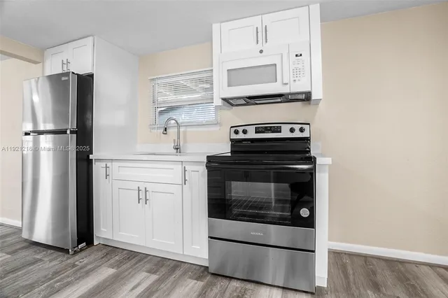 a kitchen with cabinets and stainless steel appliances