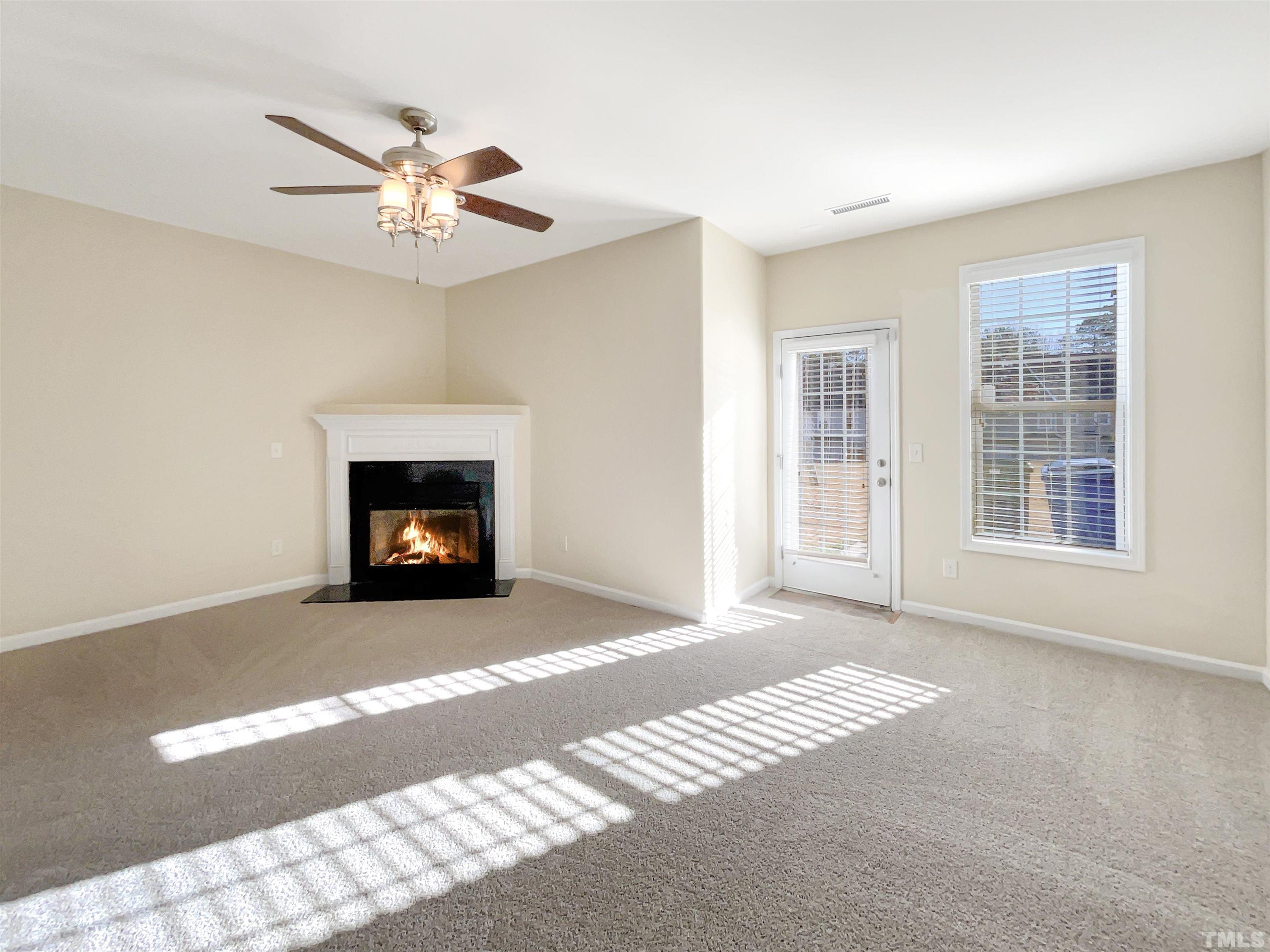 3240 Warm Springs Lane Raleigh, NC 27610 - Photo 8 of 18 a view of an empty room with a fireplace and a window