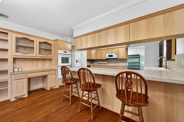 a kitchen with a sink cabinets stainless steel appliances and wooden floor