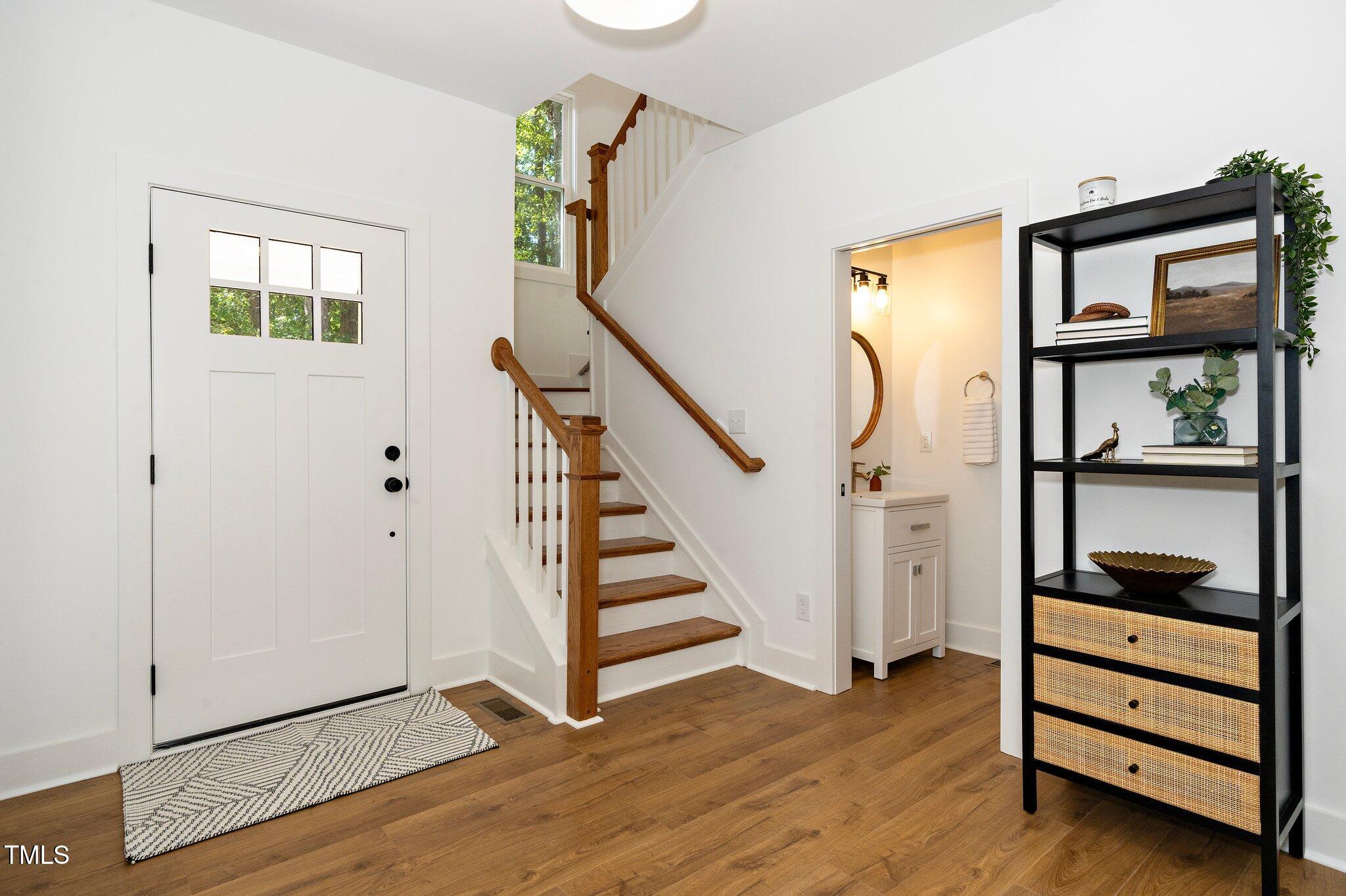 8112 Rhudy Place Raleigh, NC 27612 - Photo 11 of 39 a view of entryway with wooden floor and stairs