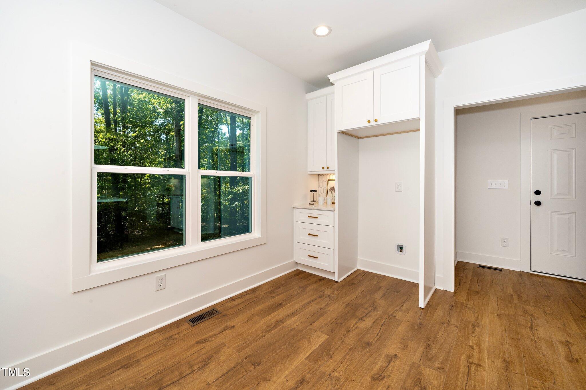 8112 Rhudy Place Raleigh, NC 27612 - Photo 19 of 39 an empty room with wooden floor and windows