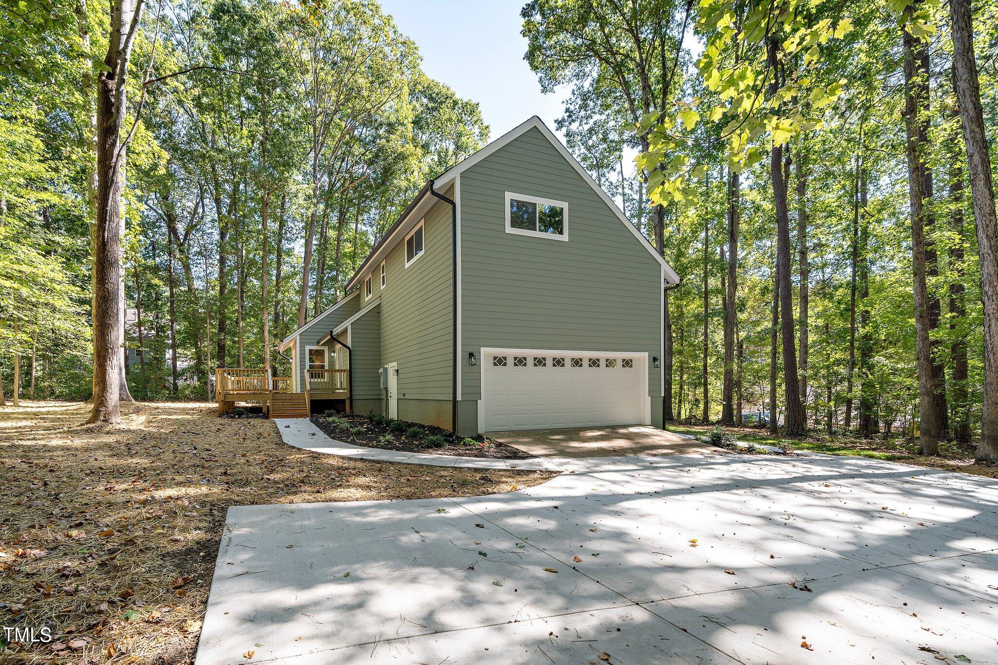 8112 Rhudy Place Raleigh, NC 27612 - Photo 36 of 39 a view of a blue house with yard and large trees