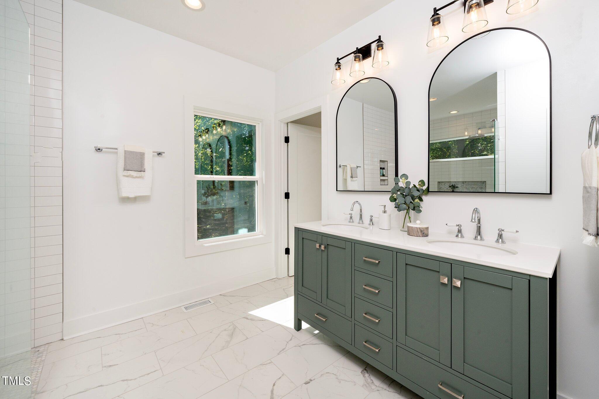 8112 Rhudy Place Raleigh, NC 27612 - Photo 7 of 39 a spacious bathroom with a double vanity sink a mirror and a