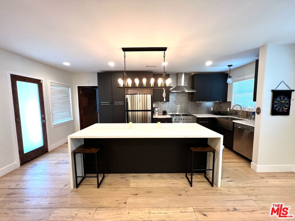 5757 Vesper Avenue Van Nuys, CA 91411 - Photo 5 of 18 a room with table chairs stainless steel appliances and wooden floor