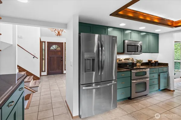 a kitchen with stainless steel appliances granite countertop a refrigerator and a stove top oven