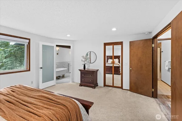 a bedroom with a bed and a dresser with mirror