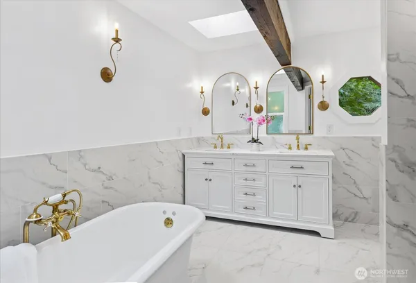 a bathroom with a tub sink and mirror