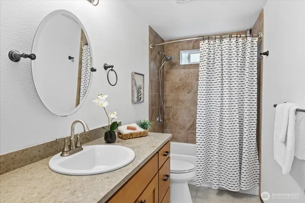 a bathroom with a sink a toilet and shower curtain