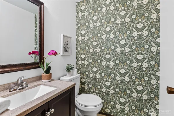a bathroom with a granite countertop sink and a toilet
