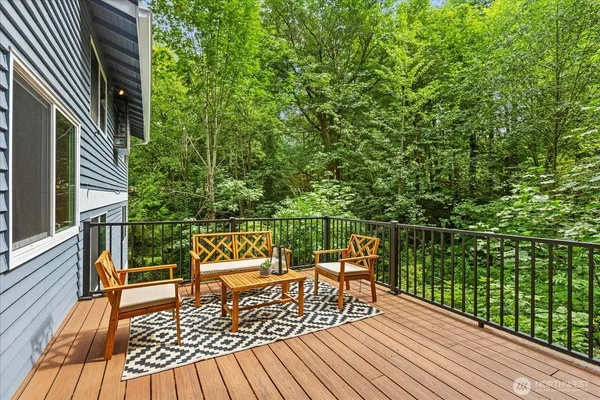 a balcony with wooden floor table and chairs