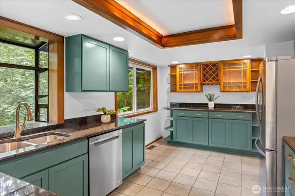 a kitchen with a sink and large windows