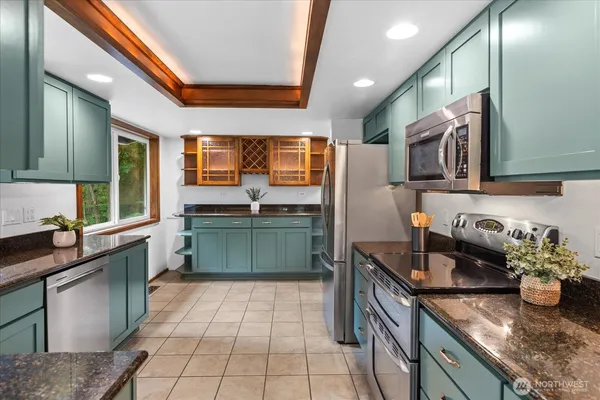 a kitchen with stainless steel appliances granite countertop a sink stove and cabinets