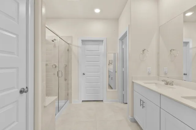 a bathroom with a double vanity sink mirror and shower