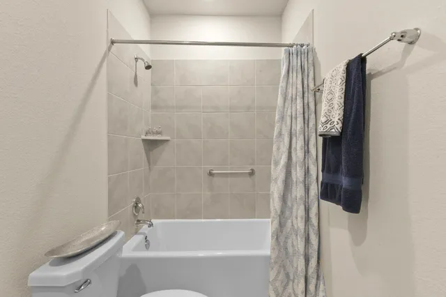 a bedroom with a bed and large windows