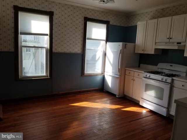 a kitchen with granite countertop wooden floors and stainless steel appliances