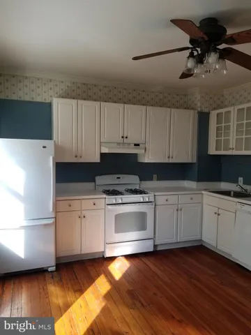 a kitchen with granite countertop a stove a sink and a refrigerator