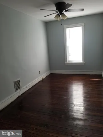 en empty room with wooden floor and windows