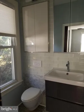 a bathroom with a sink a toilet and a mirror