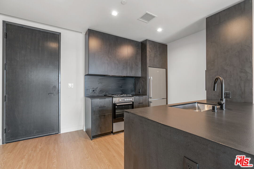 3688 Overland Avenue, Unit 521 Los Angeles, CA 90034 - Photo 3 of 31 a kitchen with stainless steel appliances a refrigerator and a stove top oven