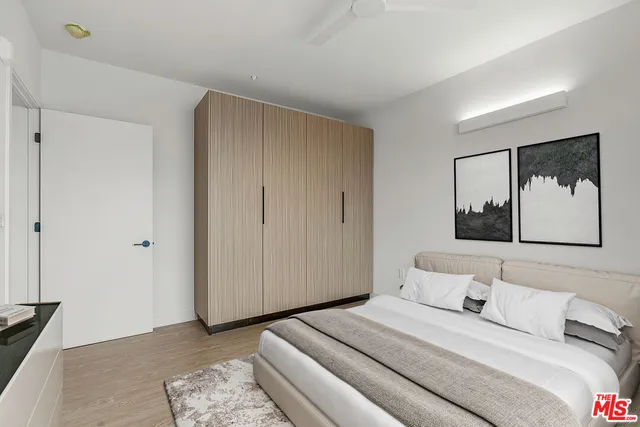 a bedroom with a bed and a painting on the wall