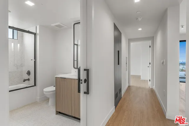 a view of a bathroom with toilet shower and mirror