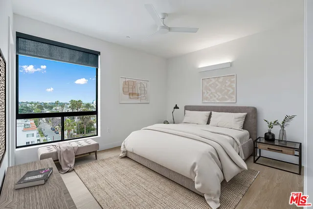 a bedroom with a bed and a large window