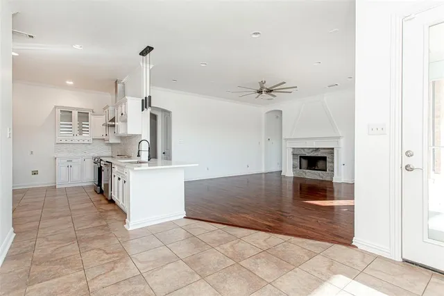 a view of an empty room with wooden floor and a fireplace