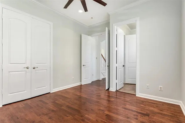 a view of a room with wooden floor and ceiling fan