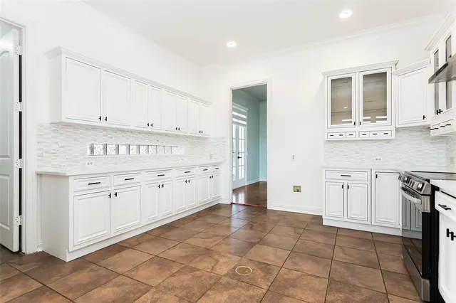 a kitchen with granite countertop white cabinets and stainless steel appliances
