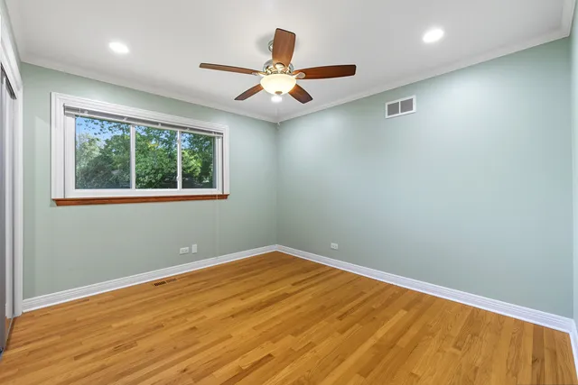 an empty room with a window and ceiling fan