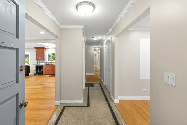 a view of a hallway with wooden floor and a living room