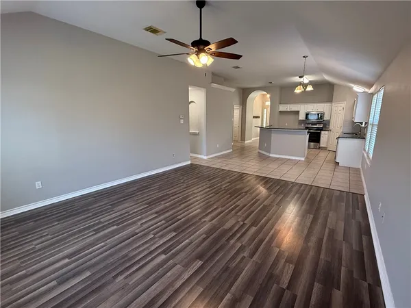 a view of a kitchen with a sink dishwasher a refrigerator with wooden floor