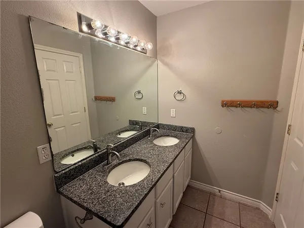 a bathroom with a granite countertop sink and a mirror