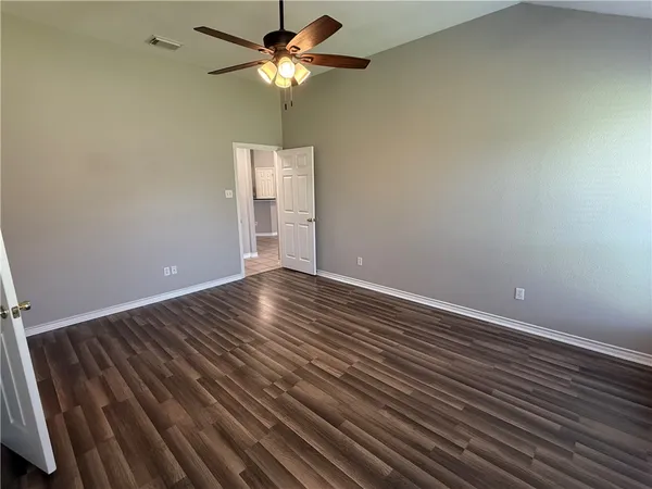 a view of room with wooden floor and ceiling fan