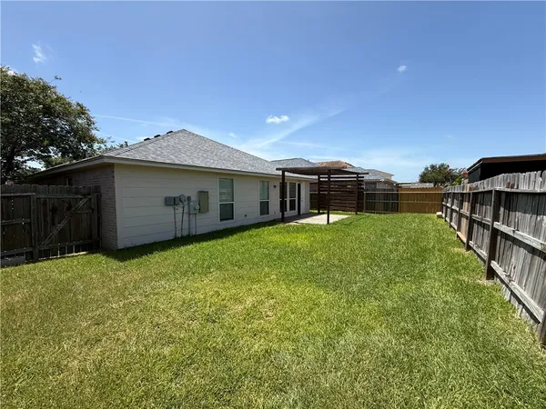 a view of a house with backyard and sitting area