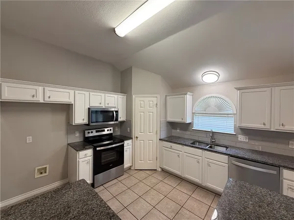 a kitchen with granite countertop a stove and a refrigerator