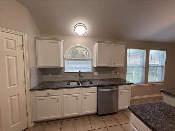 a kitchen with a sink stove and cabinets