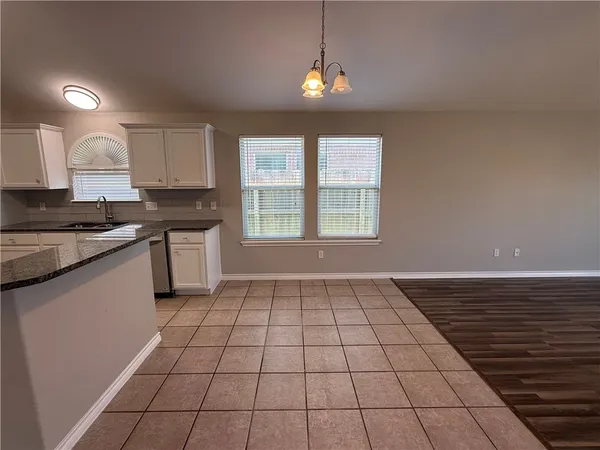 a kitchen with a sink a stove cabinets and a window